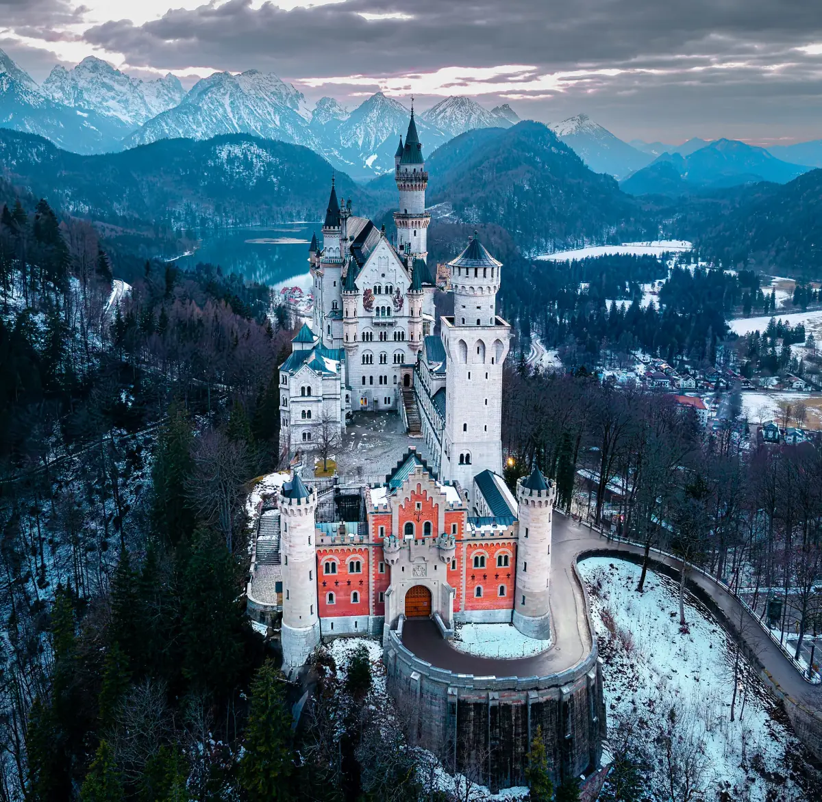 Neuschwanstein Castle seen from above with the Alps behind